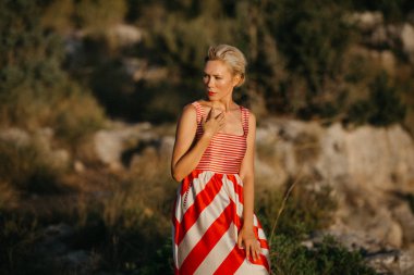 Sunset Bulvarında eski kanyonda poz kırmızı elbiseli güzel güzel sarışın manken. İspanya