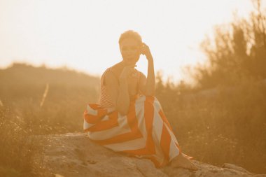 Büyük taş turuncu güneş ışığı altında Antik kanyonda poz zarif çekici genç bir kadın. İspanya