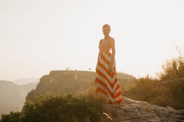 Turuncu güneş ışığı altında Antik Kanyon kenarına poz zarif oldukça genç bir kadın. İspanya