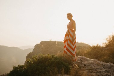 Turuncu güneş ışığı altında Antik Kanyon kenarına poz rahat güzel bir kız. İspanya