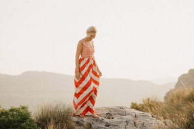 Turuncu güneş ışığı altında Antik Kanyon kenarına poz rahat güzel bir kadın. İspanya