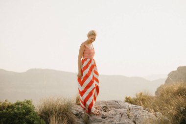 Turuncu güneş ışığı altında Antik Kanyon kenarına poz rahat oldukça genç bir kadın. İspanya