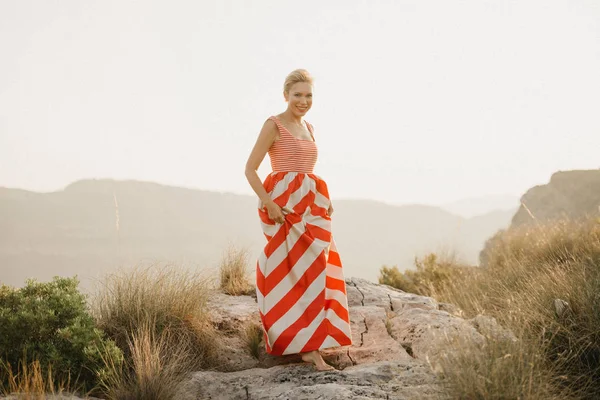 幸せなファッショナブルな美しい若い女性オレンジ日光で古代峡谷の端にポーズします スペイン — ストック写真