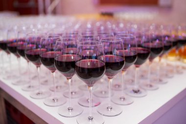 Bir restoranda kırmızı şarap ile şarap gözlükleri bir sürü. 