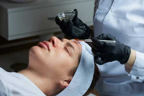 Een Vrouwelijke Cosmetoloog Die Zwarte Wegwerphandschoenen Draagt Gebruikt Een Borstel — Stockfoto