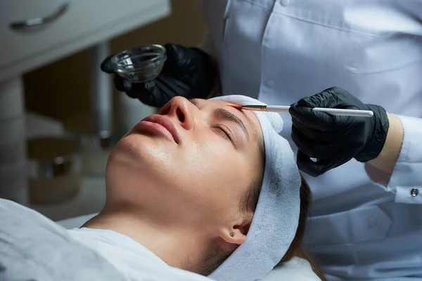 Kobieta Kosmetolog Nosząca Czarne Jednorazowe Rękawice Medyczne Używa Pędzla Nakładania — Zdjęcie stockowe
