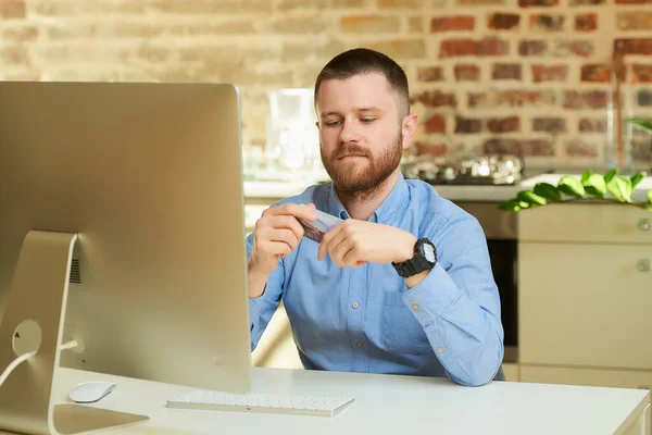 Ein Mann Mit Bart Hält Eine Kreditkarte Der Hand Und — Stockfoto