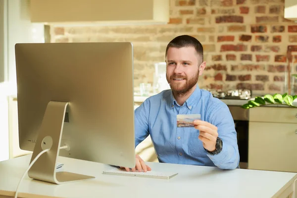 Hombre Feliz Sienta Frente Computadora Escribe Una Información Tarjeta Crédito — Foto de Stock