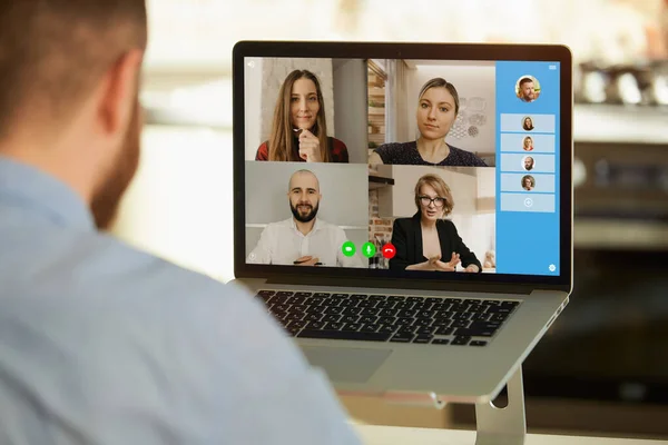 回顾一下一个男人在家里的笔记本电脑上通过视频电话远程工作 听同事们谈生意的情景 在网上会议上与一个商业团队一起展示计算机的近照 — 图库照片