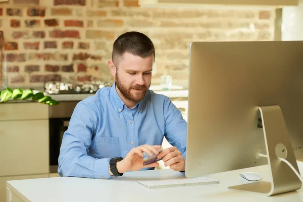 Hombre Con Barba Pensando Compras Línea Mientras Sostiene Una Tarjeta — Foto de Stock