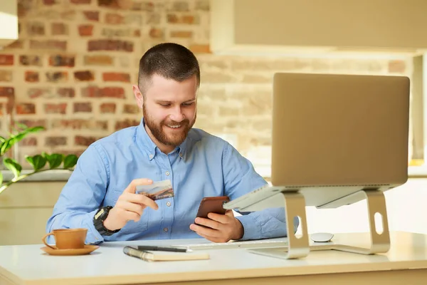 Hombre Feliz Con Barba Usando Teléfono Inteligente Sosteniendo Una Tarjeta — Foto de Stock