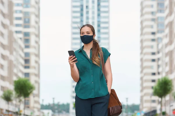 Mujer Con Una Máscara Facial Médica Lee Noticias Teléfono Inteligente — Foto de Stock