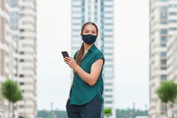 Una Vista Lateral Mujer Una Mascarilla Médica Lee Noticias Teléfono —  Fotos de Stock