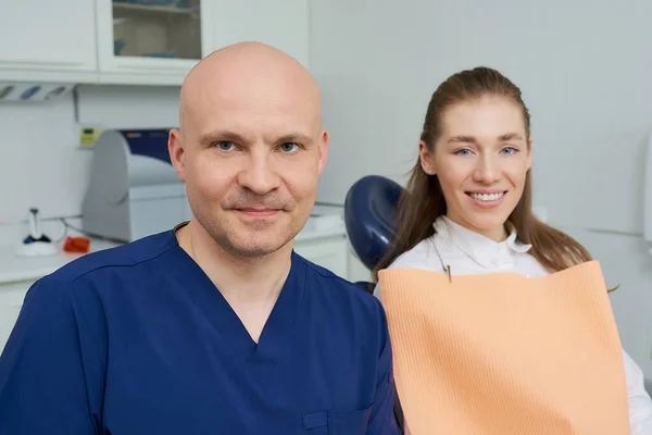 Skallig Medelålders Tandläkare Och Ganska Leende Kvinnlig Patient Poserar Tandläkares — Stockfoto