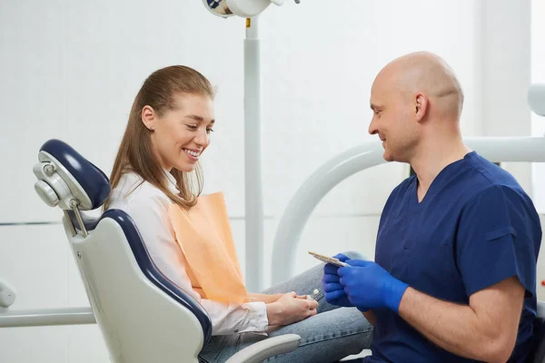 Bald Middle Aged Dentist Shows Smiling Female Patient Tooth Color — Stock Photo, Image