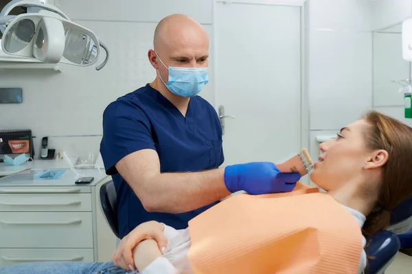 Dentista Careca Meia Idade Escolhe Sombra Dente Para Uma Paciente — Fotografia de Stock