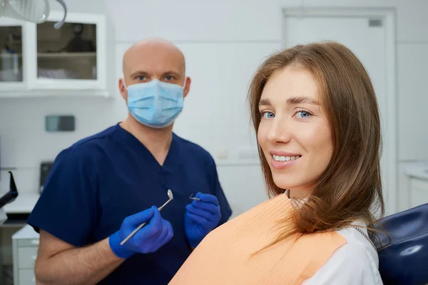 Ein Glatzköpfiger Zahnarzt Mit Medizinischer Gesichtsmaske Hält Einen Zahnspiegel Und — Stockfoto