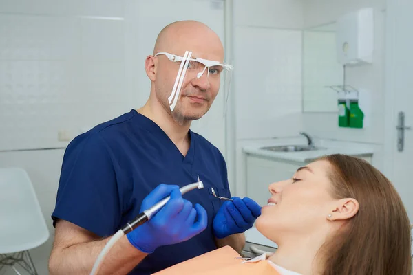 Bald Dentist Medical Face Shield Holds Dental Mirror Drill Lying — Stock Photo, Image