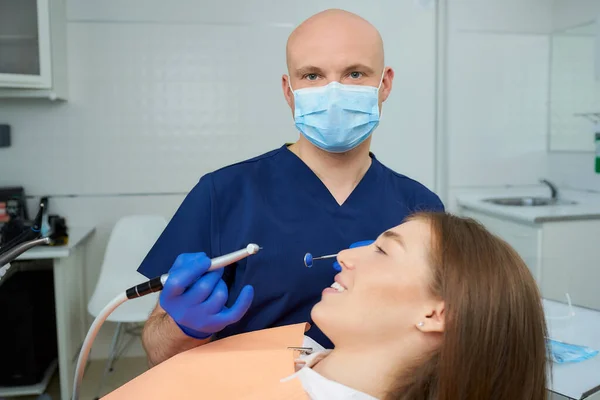 Dentista Calvo Con Una Mascarilla Médica Sostiene Espejo Dental Perfora — Foto de Stock
