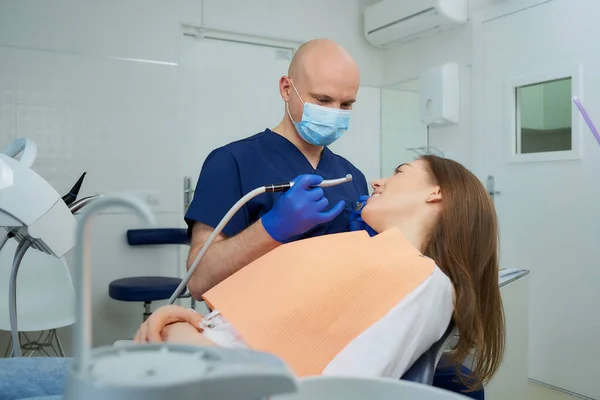 Tandläkare Medicinsk Ansiktsmask Håller Tandspegel Och Borrar Nära Liggande Ung — Stockfoto