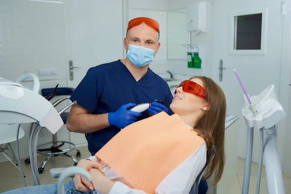 Ein Zahnarzt Mit Medizinischer Gesichtsmaske Und Schutzbrille Hält Ein Zahnärztliches — Stockfoto
