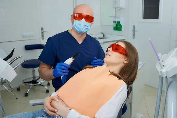 Ein Zahnarzt Mit Medizinischer Gesichtsmaske Und Schutzbrille Hält Ein Zahnärztliches — Stockfoto