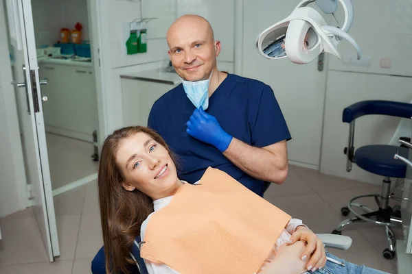 Dentista Calvo Bajó Mascarilla Médica Cerca Una Paciente Sonriente Consultorio — Foto de Stock