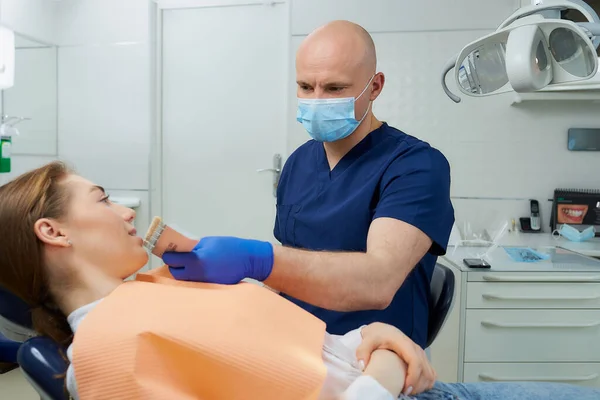 Dentista Careca Meia Idade Escolhe Sombra Dente Para Uma Paciente — Fotografia de Stock