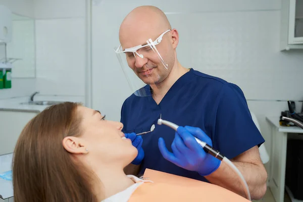 Skaldet Glad Midaldrende Tandlæge Medicinsk Ansigtsskjold Begyndte Behandle Kvindens Tænder - Stock-foto