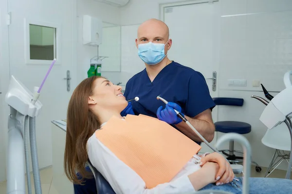 Dentista Con Una Mascarilla Médica Sostiene Espejo Dental Posa Cerca —  Fotos de Stock