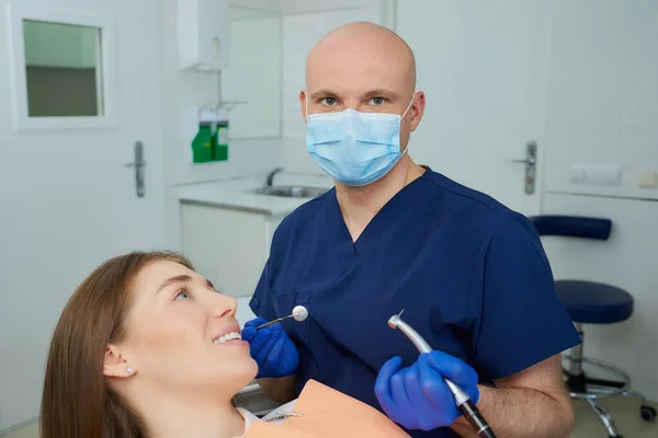 Dentista Con Una Mascarilla Médica Sosteniendo Espejo Dental Taladro Posa — Foto de Stock