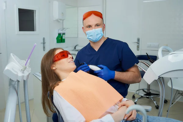 Tandläkare Medicinsk Ansiktsmask Och Skyddsglasögon Som Håller Tandpolymerisering Ljus Nära — Stockfoto