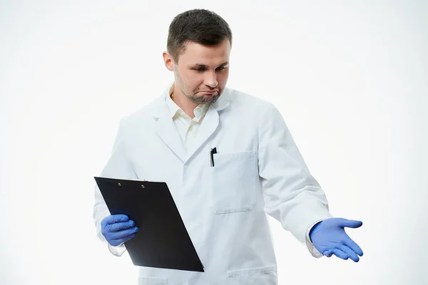 白い研究室のコートと青い使い捨て医療用手袋の幸せな男性の原因医師は 彼の手で指しています 科学者は白地に隔離されている — ストック写真