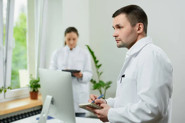 Médico Caucásico Está Haciendo Notas Con Una Pluma Cerca Una —  Fotos de Stock