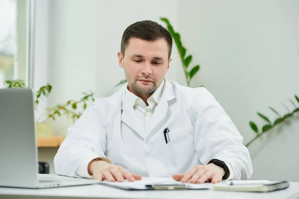 Médico Caucásico Serio Con Una Bata Blanca Laboratorio Está Sentado — Foto de Stock