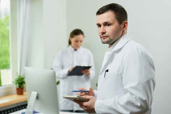 Médico Caucásico Queda Con Cuaderno Bolígrafo Hospital Una Terapeuta Está — Foto de Stock