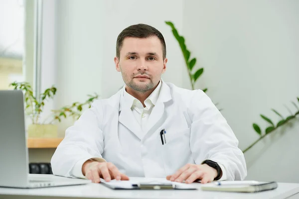 Buen Médico Caucásico Con Una Bata Blanca Laboratorio Está Sentado — Foto de Stock