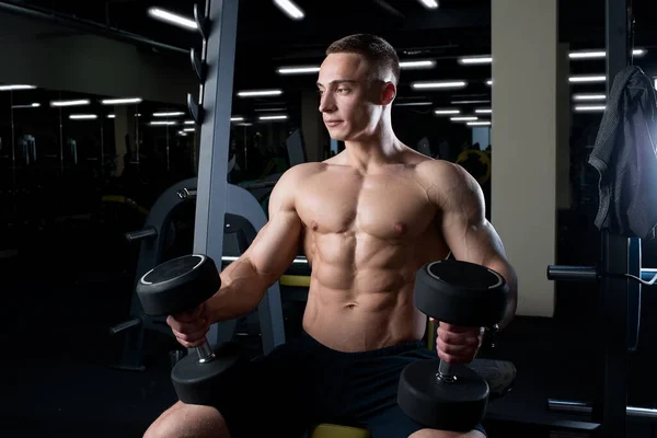 Ein Muskulöser Mann Ohne Hemd Hält Einem Fitnessstudio Hanteln Auf — Stockfoto
