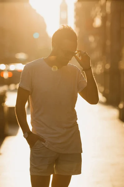 Ein Mann Weißem Shirt Und Kurzer Hose Richtet Seine Sonnenbrille — Stockfoto