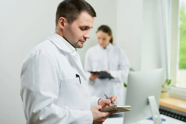 Médico Caucásico Con Cuaderno Bolígrafo Registra Historia Clínica Los Pacientes —  Fotos de Stock