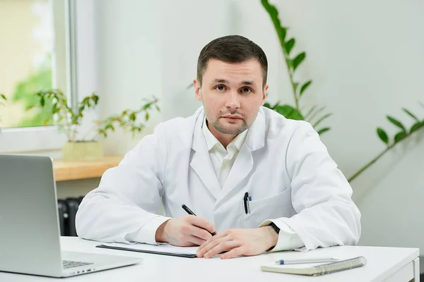 Кавказький Лікар Білій Лабораторній Шубці Заповнює Картку Пацієнта Діагнозом Прослуховуванням — стокове фото