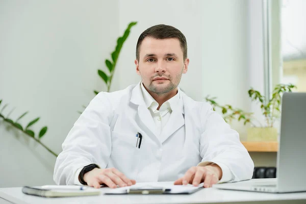 Buen Médico Caucásico Con Una Bata Blanca Laboratorio Está Sentado —  Fotos de Stock