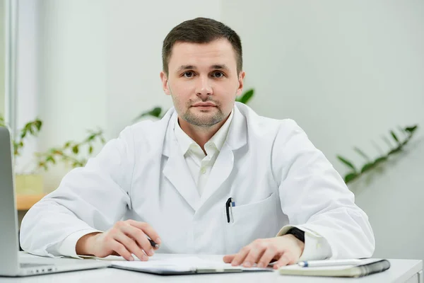 Médico Caucásico Con Una Bata Blanca Laboratorio Está Sentado Escritorio —  Fotos de Stock