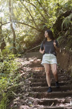 Sırtında sırt çantasıyla tropik ormanda yürüyen ve keşfeden İspanyol gezgin- Guatemala'da seyahat eden Latin kadın