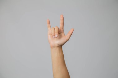 Kaya sembolü yapan adamın eli, sallanan adamın eli