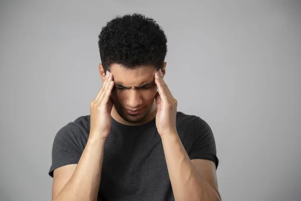 Kafası olan İspanyol bir adam. Ellerini başının üstüne koyup aşağıya bakan genç bir esmer.