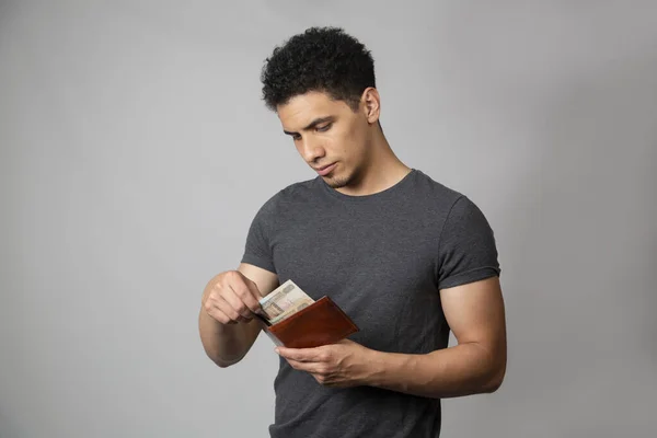 Young Hispanic man checking his wallet - sad man watching his money — Stock Photo, Image