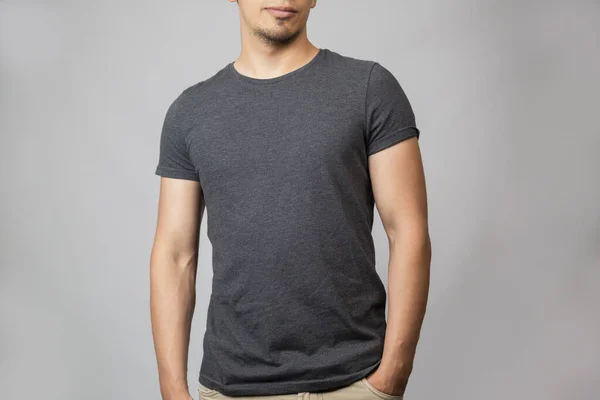 Gray t-shirt template - front man in studio with gray background — Stock Photo, Image