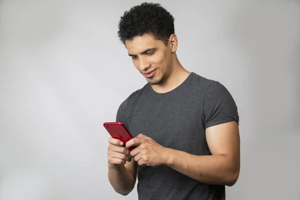 İspanyol bir adam cep telefonundan mesaj yolluyor. Akıllı telefonunu izleyen genç bir adam.