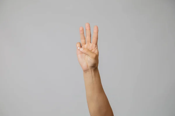 Männerhand mit Nummer drei, Hand hebt drei Finger im Studio mit grauem Hintergrund nach oben — Stockfoto